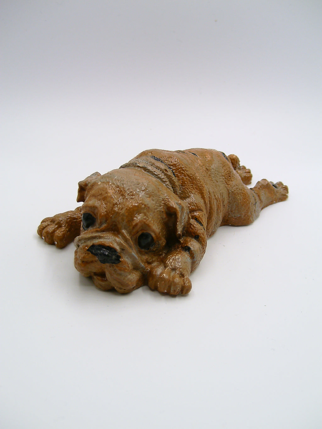 Bulldoggen-Figur aus Gips – liegend mit ausgestreckten Pfoten