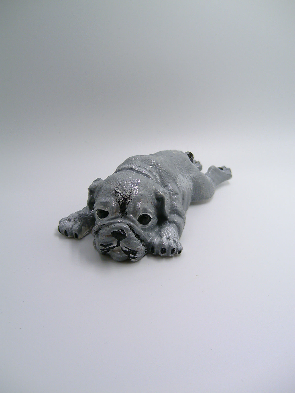 Bulldoggen-Figur aus Gips – liegend mit ausgestreckten Pfoten