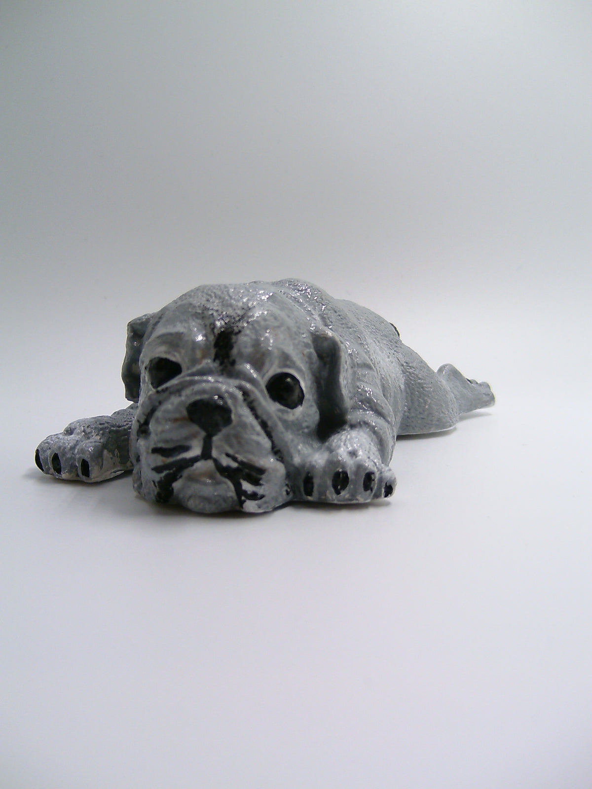 Bulldoggen-Figur aus Gips – liegend mit ausgestreckten Pfoten